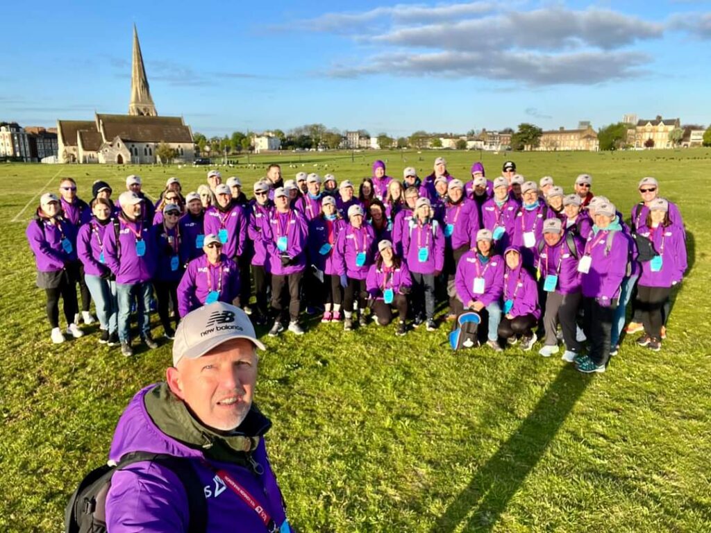 A group of London Marathon volunteers wearing purple jackets